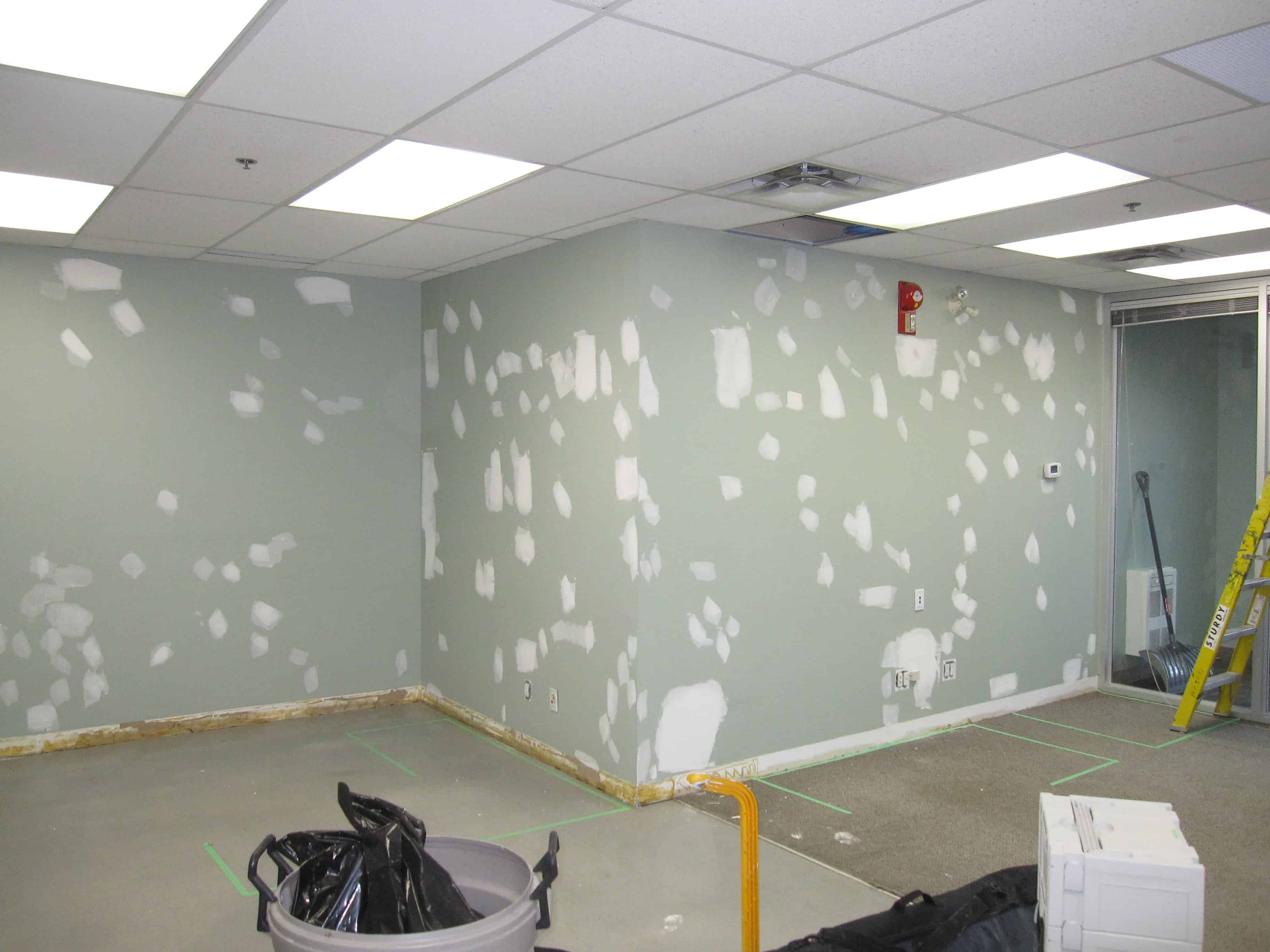 Before drywall repairs are primed and painted in Calgary office reception area walls